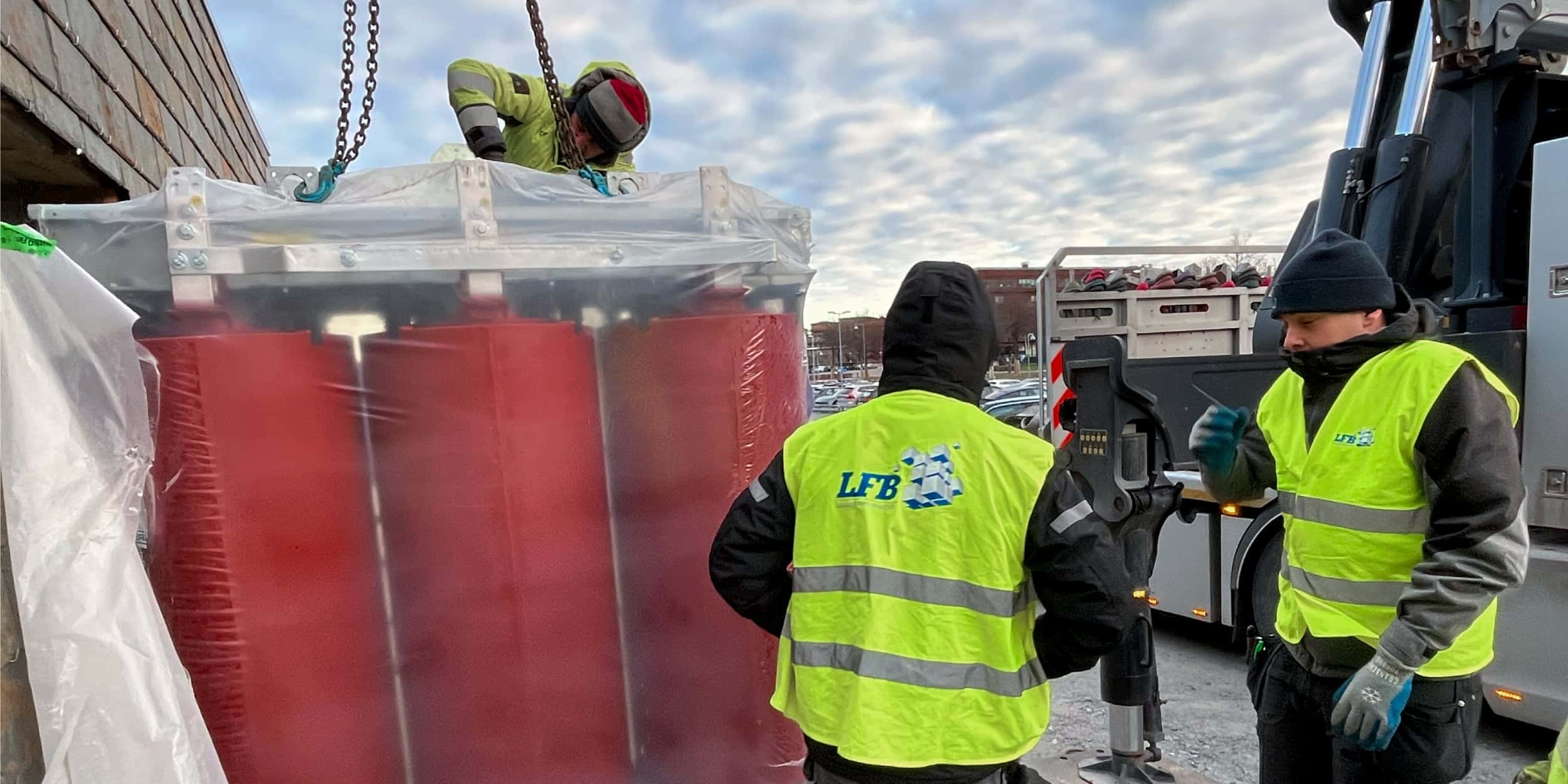 Flyttfirma som arbetar med ett tungt lyft av en maskin